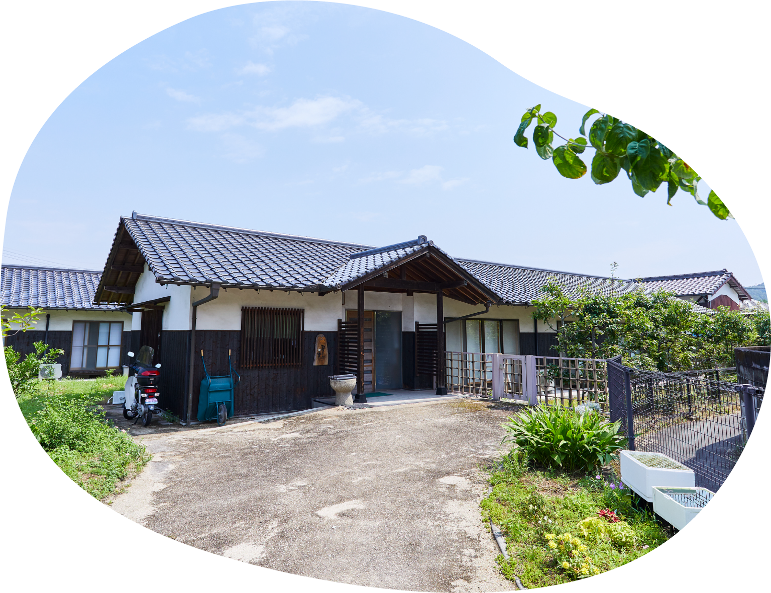和風の平屋建て介護施設の外観。玄関周りと駐車スペースが見える。
